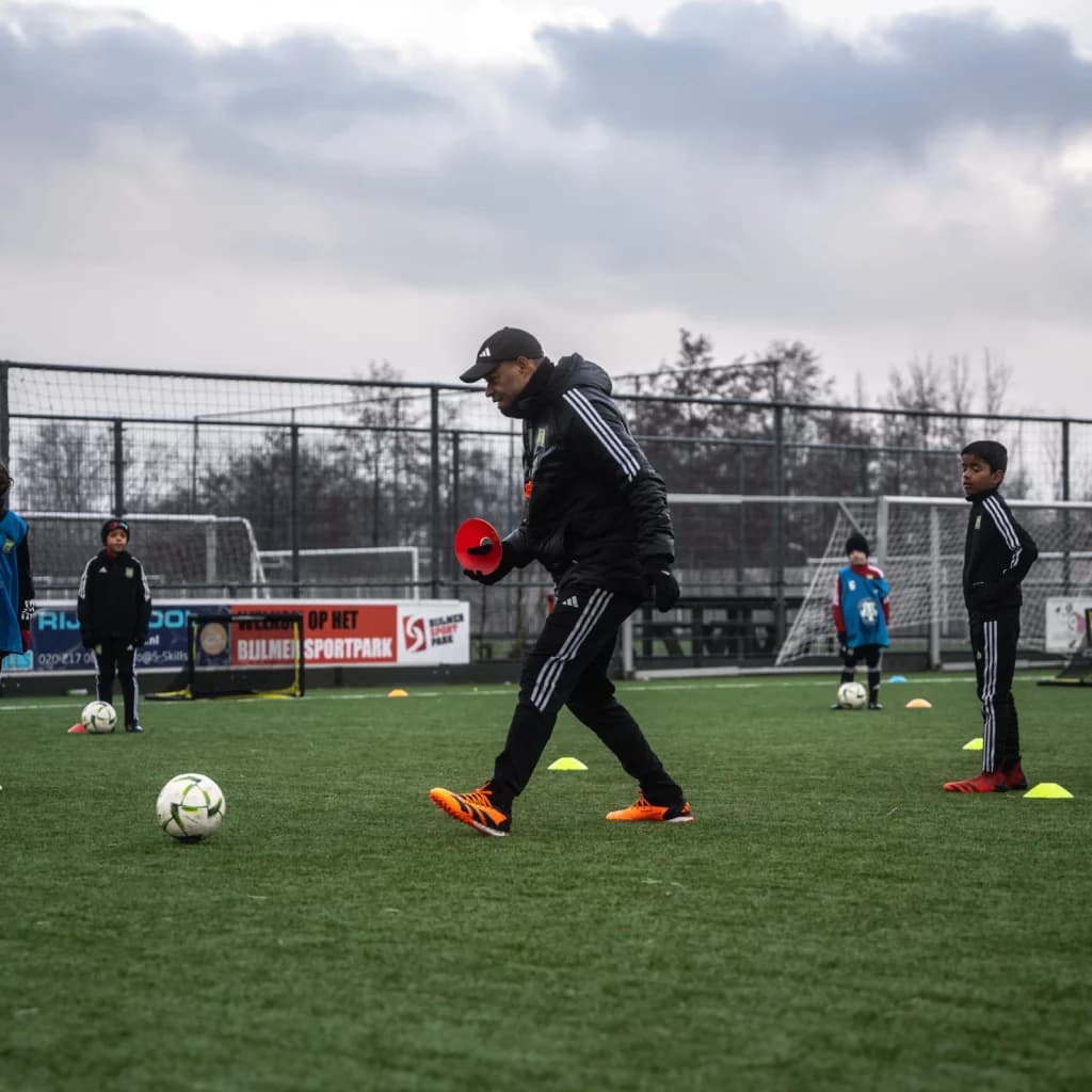 Voetbaltrainer tijdens een technische veldtraining